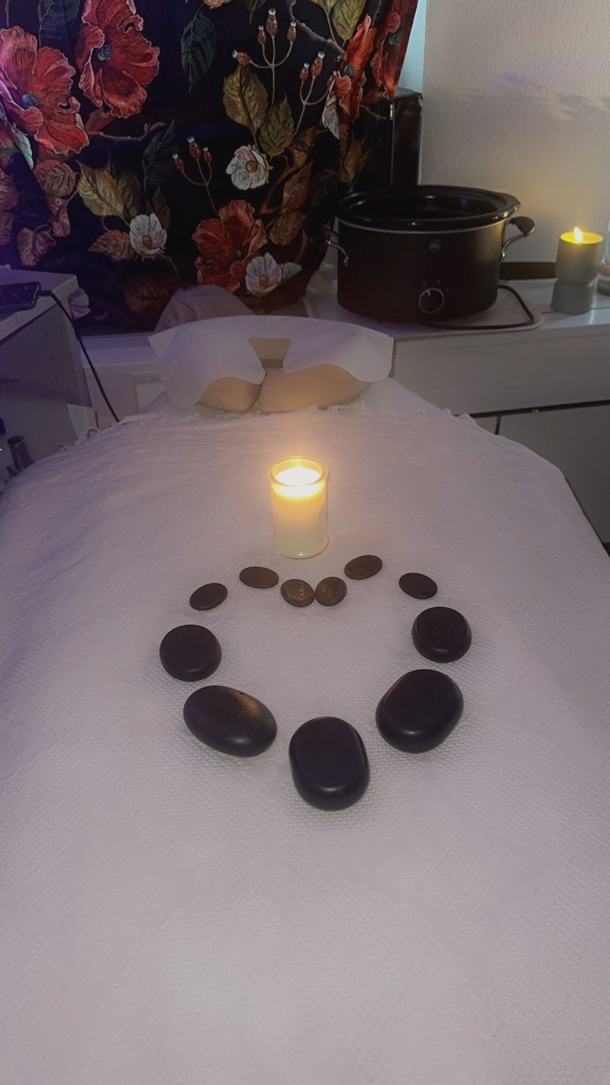 Varma naturstenar och ljus för japansk hot stone-massage